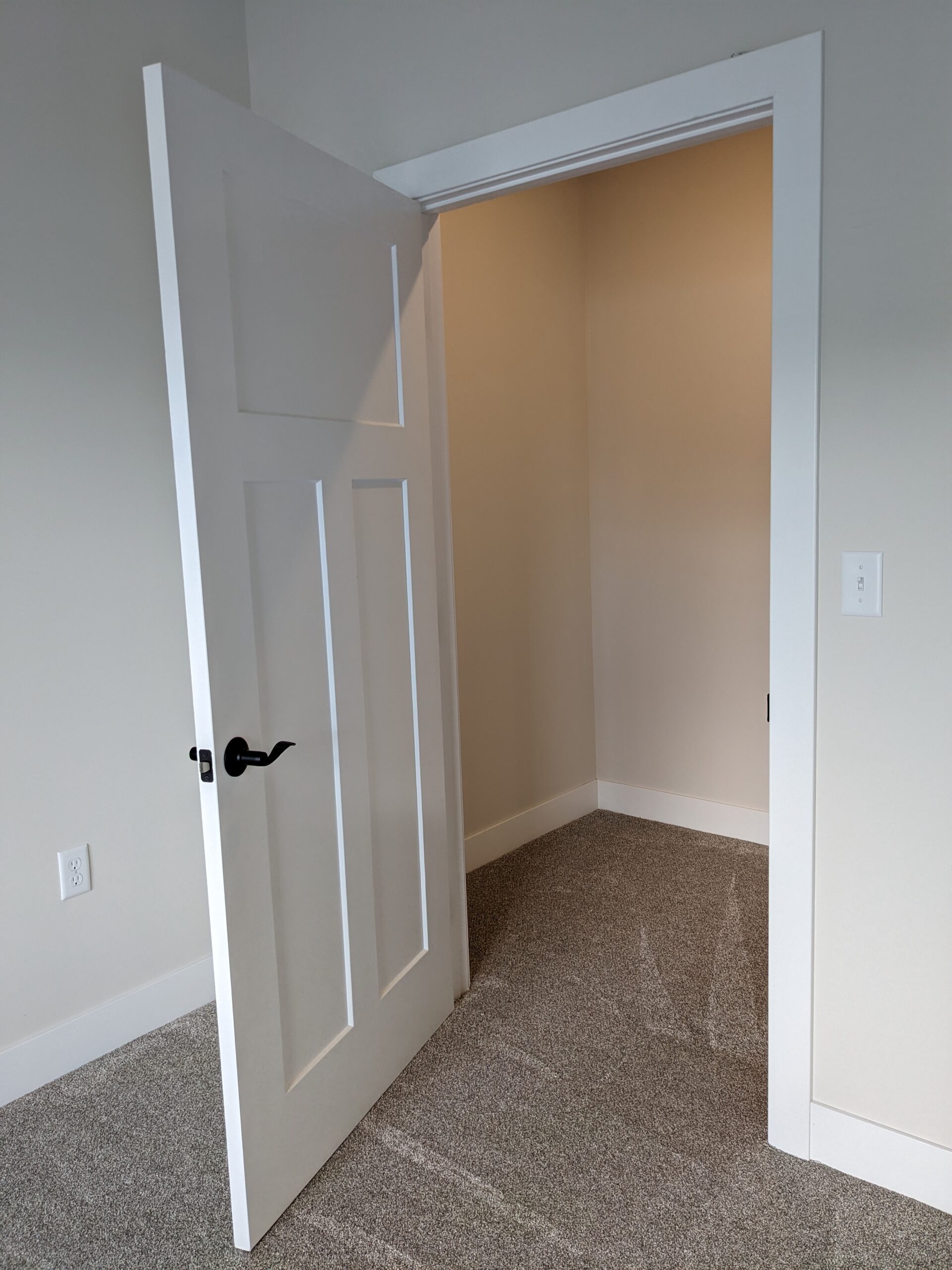 A white wall with a black and red sign on it