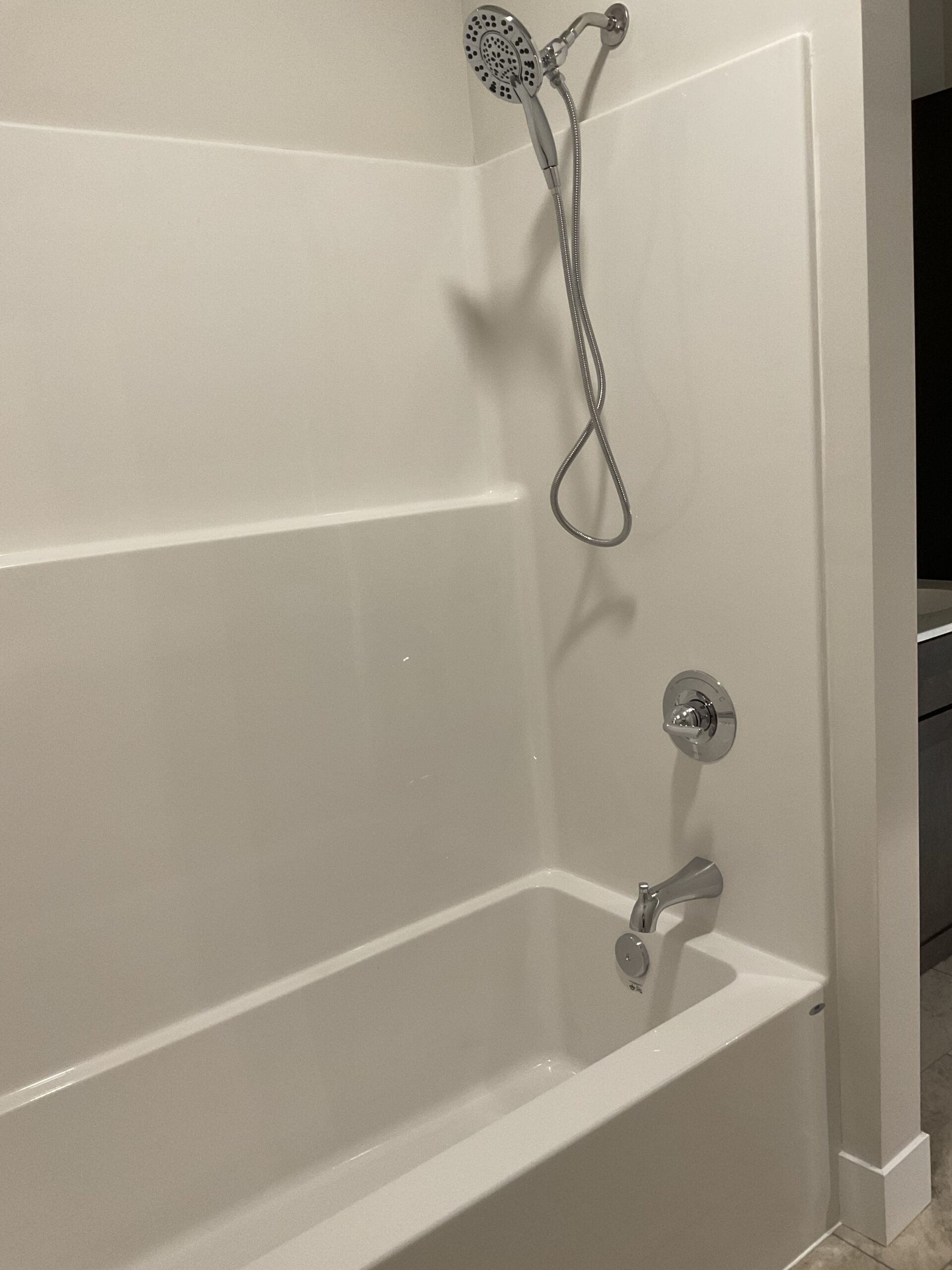 Low rise bathtub with offset spout and controls before grab bars